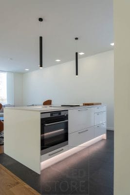 An island with indirect light in the plinth. The islet is also lit by LedStore's Piippu luminaires. General lighting is provided by panel luminaires. Ledstore.fi