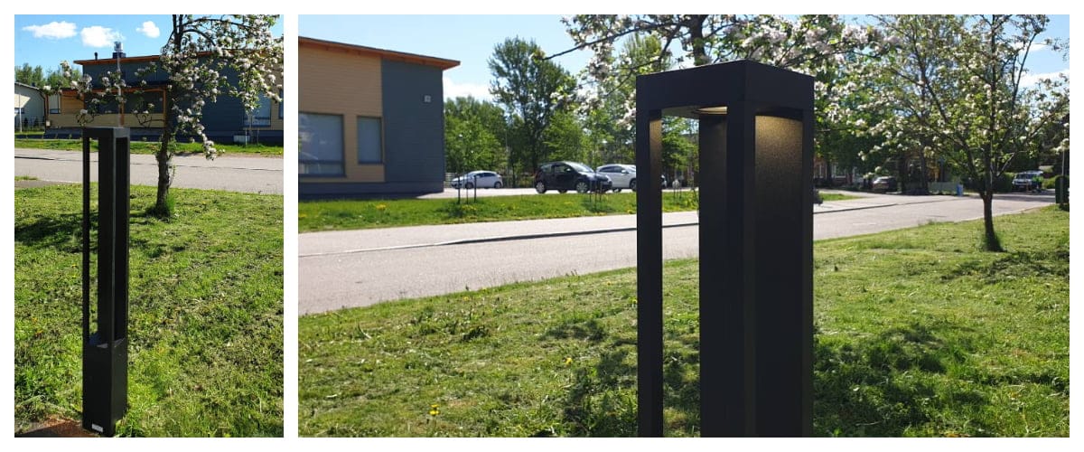 - LedStore Moderni ulkona oleva LED-valaisinpylväs nurmikolla lähellä tietä, tyylikäs suorakaiteen muotoinen muotoilu, puita lehtineen aurinkoisen taivaan alla, rakennus taustalla. Energiatehokas valaistus.