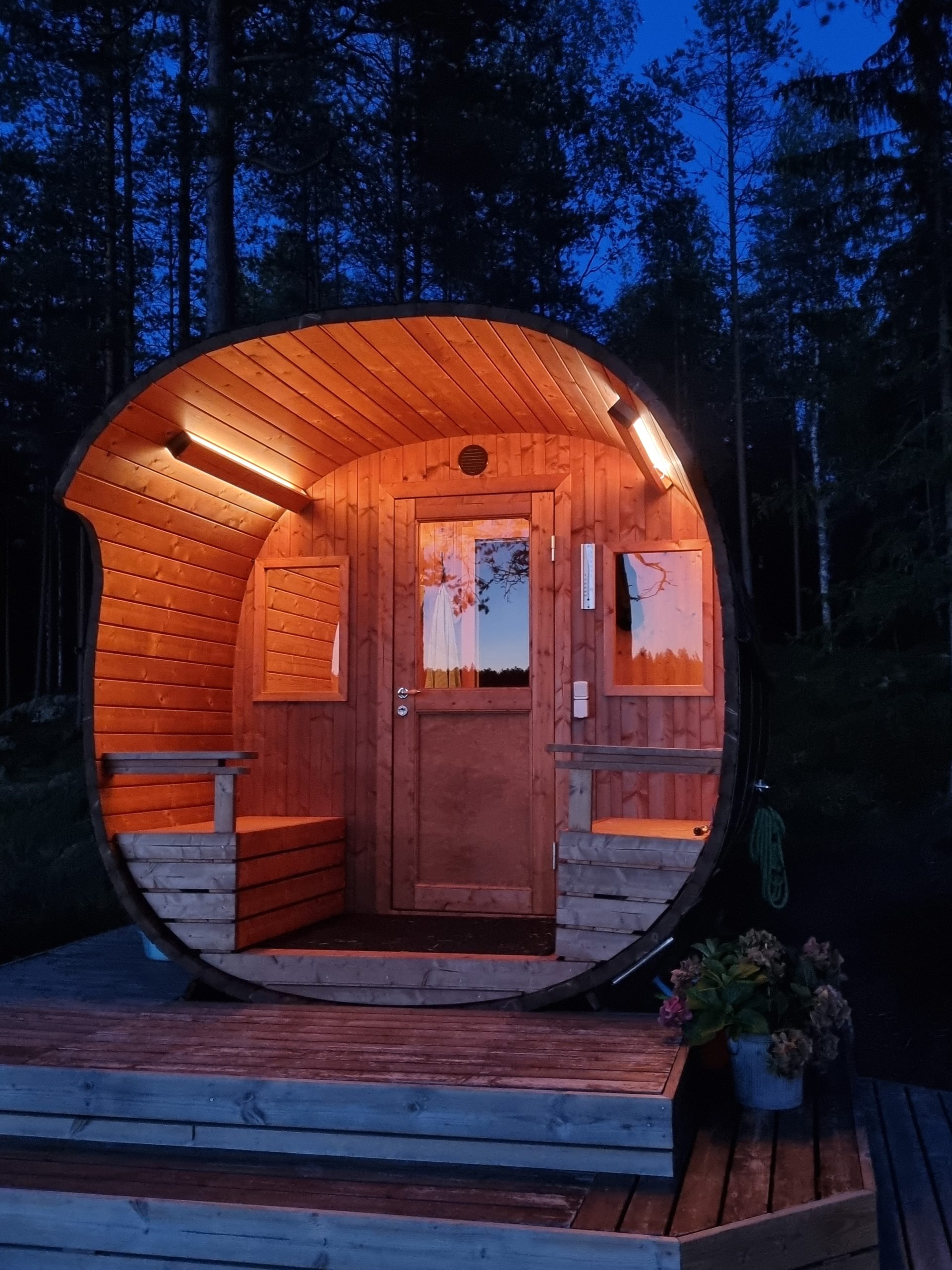 Sauna in der Abenddämmerung - LedStore LedStore.fi:n valikoimaan kuuluva kaarevaksi muotoiltu, valaistu Sauna on asetettu puualustalle keskelle pimeää metsää. Die Sauna verfügt über einen LED-Beleuchtungskörper, der die Sauna über und über in die Höhe treibt. Es ist nicht einfach, die Siluetit-Funktion zu erweitern.