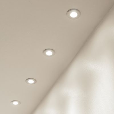 Lampada da soffitto con cinque luci LED incastonate in fila, che emettono una luce delicata su una superficie beige. Ideale per un'illuminazione moderna ed efficiente dal punto di vista energetico.