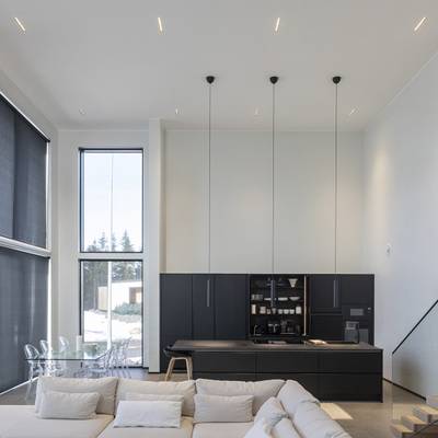 Illuminazione moderna della cucina con luci a sospensione, luce naturale da grandi finestre, LED d'ambiente e d'accento.