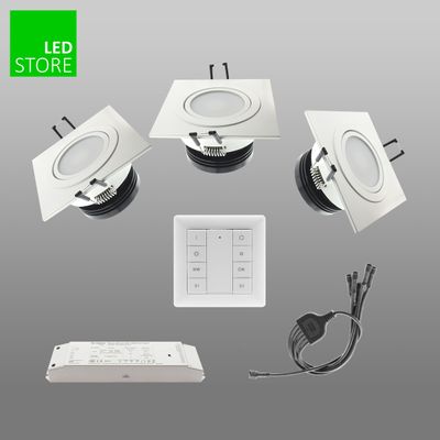 Luci LED rotonde da incasso, interruttore a parete, alimentatore e cablaggio su sfondo grigio, "LED STORE" in verde - le basi dell'illuminazione a risparmio energetico.