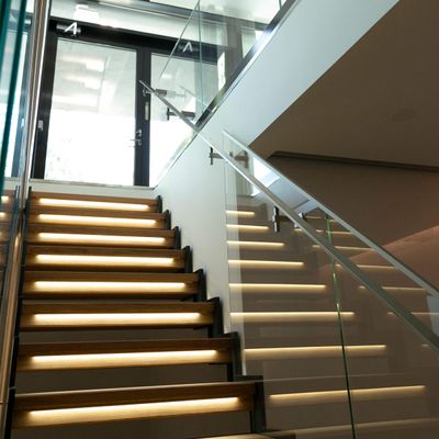 L'illuminazione delle scale illumina le scale in vetro; le moderne luci a LED esaltano l'atmosfera degli interni, con la luce naturale sovrastante.