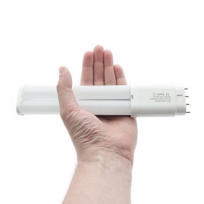 Una grande lampada fluorescente bianca in mano, che mette in evidenza le opzioni di illuminazione a LED ad alta efficienza energetica su uno sfondo bianco minimalista.