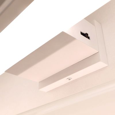 Primo piano di una lampada da gioco a led montata a parete. Sul coperchio della lampada è visibile un interruttore.