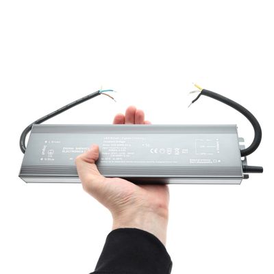 Controller LED rettangolare con fili in mano, su sfondo bianco - soluzioni di illuminazione ad alta efficienza energetica nel nostro negozio di LED.