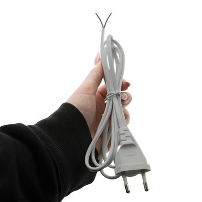 Cavo di alimentazione per lampada LED portatile, fili in evidenza, sfondo bianco, accessorio elettrico.