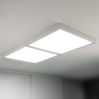 Plafoniere a LED: due apparecchi rettangolari che emettono una luce bianca brillante, montati su un soffitto liscio e leggero. Ideali per interni moderni.