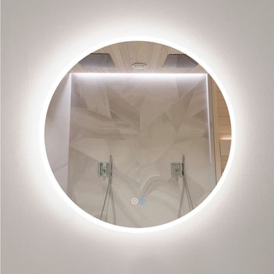 Uno specchio da bagno circolare retroilluminato a LED mette in risalto la doccia moderna, le piastrelle geometriche e la doppia illuminazione.