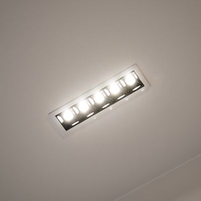 La plafoniera rettangolare da incasso con cinque lampadine LED illumina brillantemente un ambiente moderno, migliorando l'atmosfera e l'efficienza energetica.