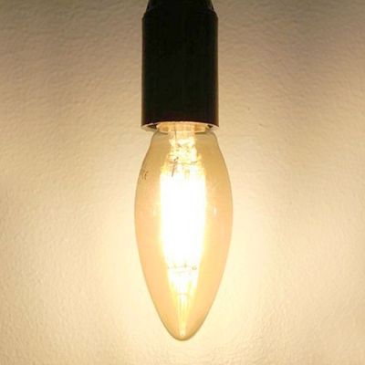 Una lampada a LED a risparmio energetico con base nera che accentua un interno moderno su una parete semplice.