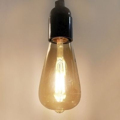 Lampada a LED vintage con base nera, appesa su uno sfondo semplice - perfetta per soluzioni di illuminazione retrò e ad alta efficienza energetica.