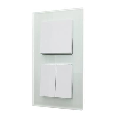 Pannello di interruttori a LED bianco contemporaneo con tre interruttori montati su un elegante pannello di vetro.