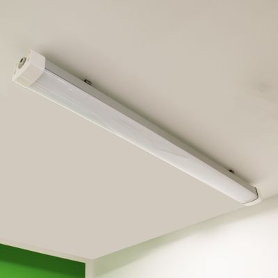 Plafoniera fluorescente con tetto bianco e parete verde nell'angolo; ideale per un'illuminazione interna ecologica.