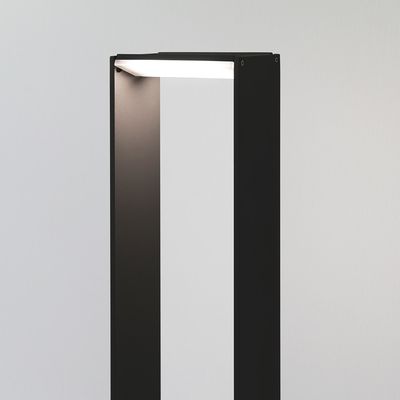 Elegante lampada da terra nera, dal design minimalista, rettangolare, aperta, con uno sfondo bianco che si illumina dolcemente. Perfetta per una moderna illuminazione a LED.