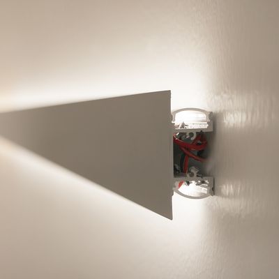 Lampada da parete minimalista con barra triangolare che mostra fili e componenti rossi. Ideale per interni moderni e per l'illuminazione a LED ad alta efficienza energetica.