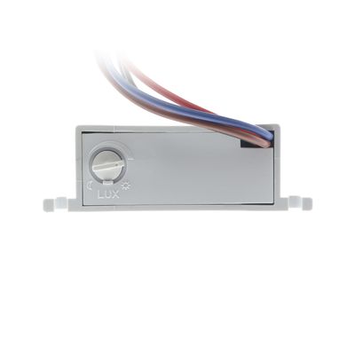 Primo piano di un apparecchio LUX grigio con fili multicolori utilizzati per controllare l'illuminazione a LED, su sfondo bianco.