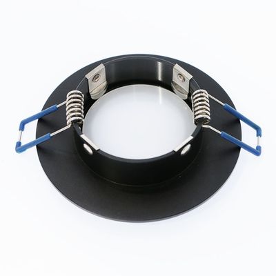 Cornice per downlight LED da incasso di colore nero con clip a molla in metallo e estremità dello stelo blu, lato superiore.