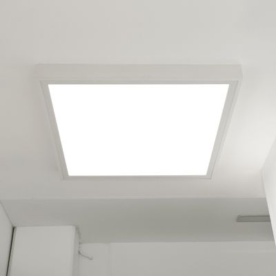 Apparecchio LED quadrato da soffitto che emette una luce bianca e brillante. È abbinato a un soffitto dal design elegante e minimalista, con angoli e spigoli vivi.