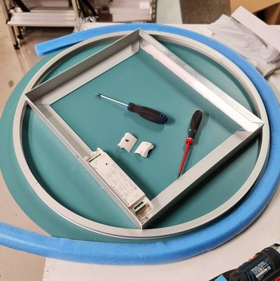 Due cacciaviti e componenti elettrici con superficie in schiuma blu-verde, strumenti d'accento per l'installazione di luci a LED.