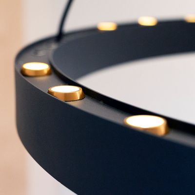 Primo piano di una luce anulare a LED circolare nera con luci dorate uniformemente distanziate, perfetta per l'illuminazione di fotografie e video.