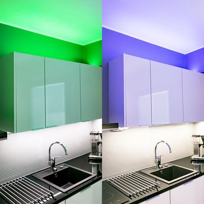 Cucina moderna con armadietti e lavello in stile, illuminata da un lato da luci LED verdi e dall'altro da luci LED blu.