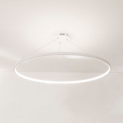 Moderna plafoniera rotonda a LED, dal design minimalista, sospesa su cavi, illuminazione bianca brillante su un soffitto bianco.
