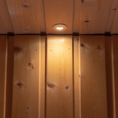 Un soffitto in legno caldo e naturale con illuminazione LED a incasso e pannelli verticali per un'atmosfera accogliente.