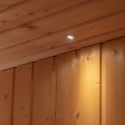 Un apparecchio LED montato a soffitto illumina i pannelli in legno della parete sottostante.