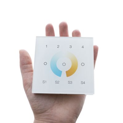 Testo alternativo: "Tenendo con la mano il pannello tattile quadrato in vetro, è possibile controllare l'illuminazione a LED con l'alimentazione, le icone di impostazione, la ruota dei colori e i pulsanti S1-S4.