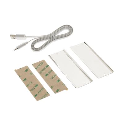 Kit di installazione per illuminazione a LED: cavo USB, strisce adesive e parti rettangolari in plastica bianca con sfondo bianco.