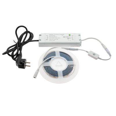 Un set di strisce LED intrecciate con alimentatore, dimmer e spina su sfondo bianco; ideale per un'illuminazione domestica personalizzabile.