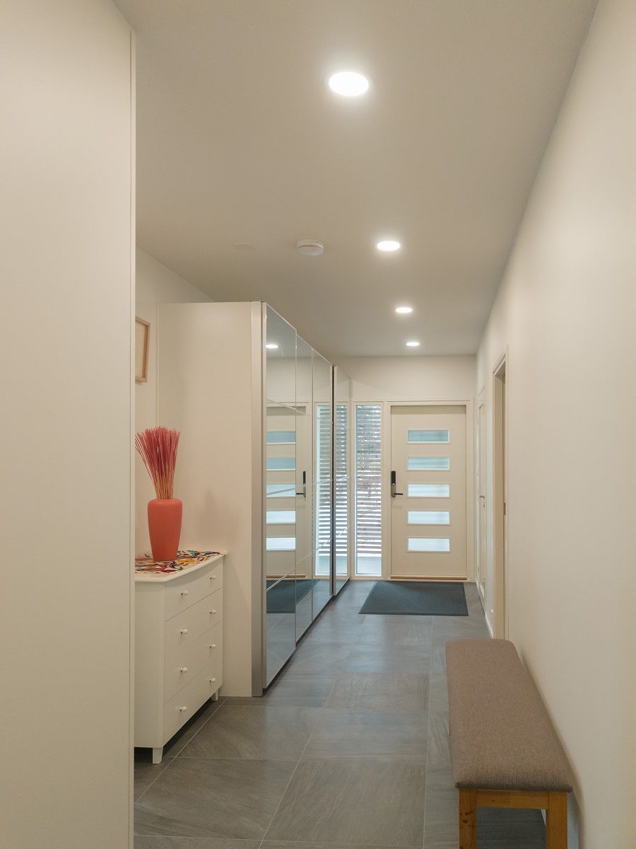 Il corridoio luminoso è illuminato da piccole lampade a pannello rotonde.