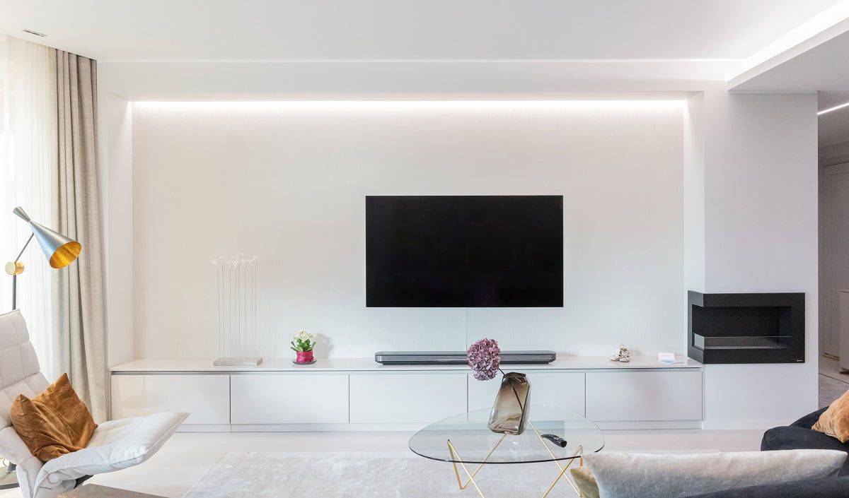 Un'illuminazione gradevole alla vista dietro una parete TV con una striscia LED indiretta nella scanalatura del soffitto. © LedStore