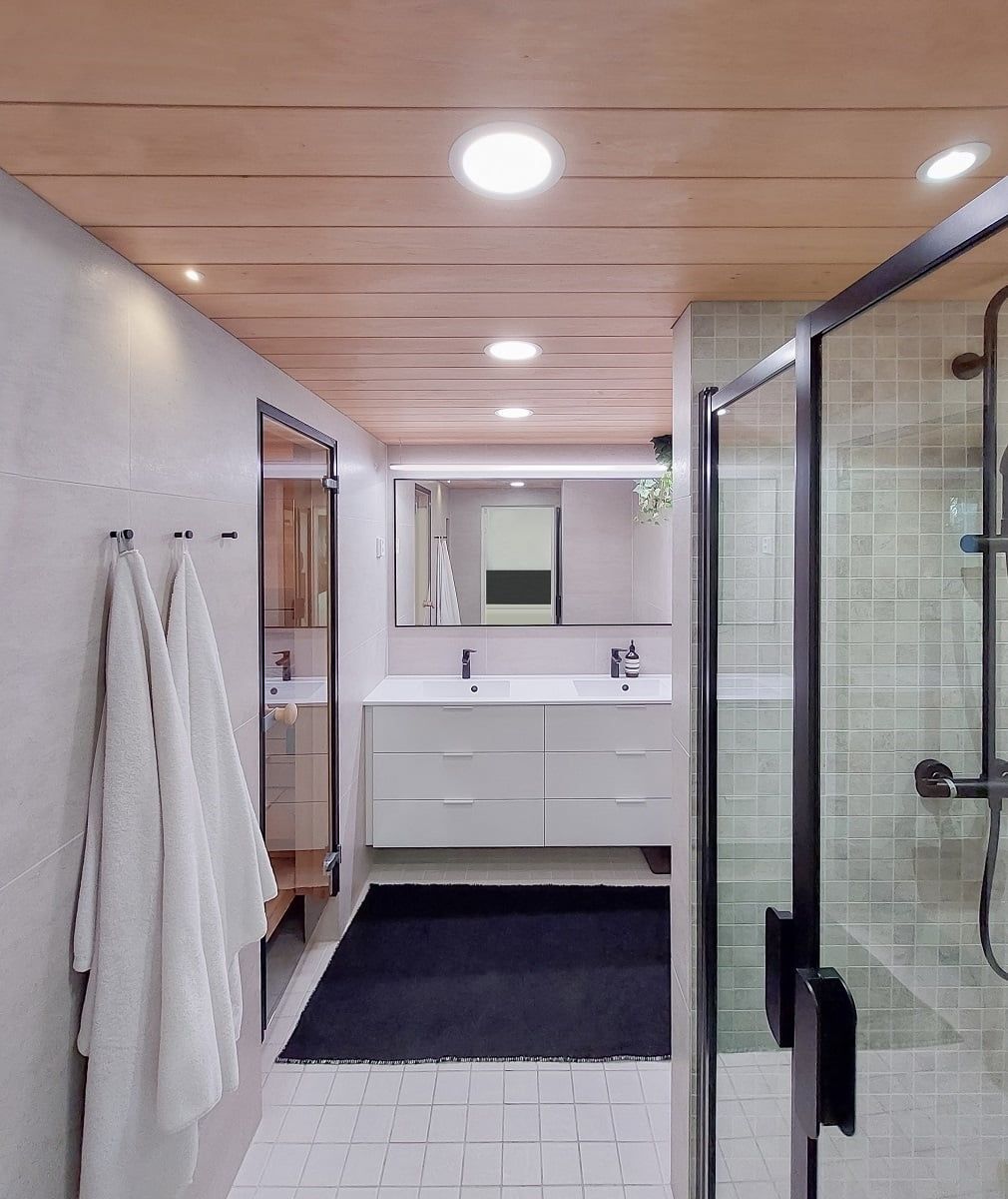 Illuminazione versatile per il bagno. Plafoniere più grandi per l'illuminazione generale, striscia LED montata su fili sopra lo specchio, faretto nella nicchia della doccia. ©LedStore