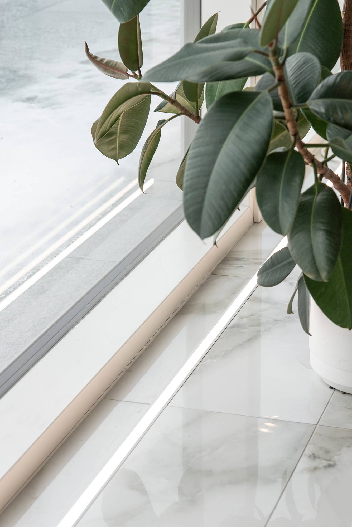 Davanti alle finestre, il pavimento è accentuato da un nastro LED nel profilo a incasso. La striscia di LED sul pavimento mette in risalto anche la splendida piastrella di marmo. Ledstore.fi