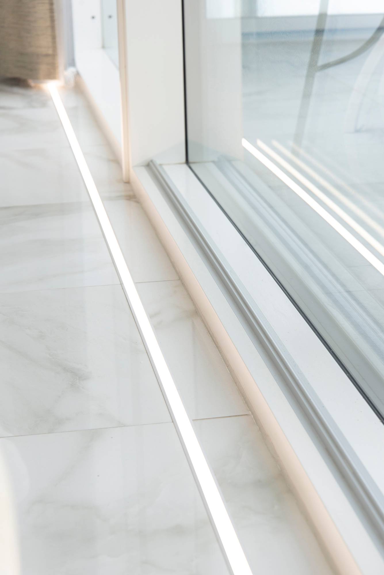 Davanti alle finestre sul pavimento in uppoprofilo la striscia led. L\'illuminazione mette in risalto le grandi finestre e il bellissimo pavimento in marmo. Ledstore.fi