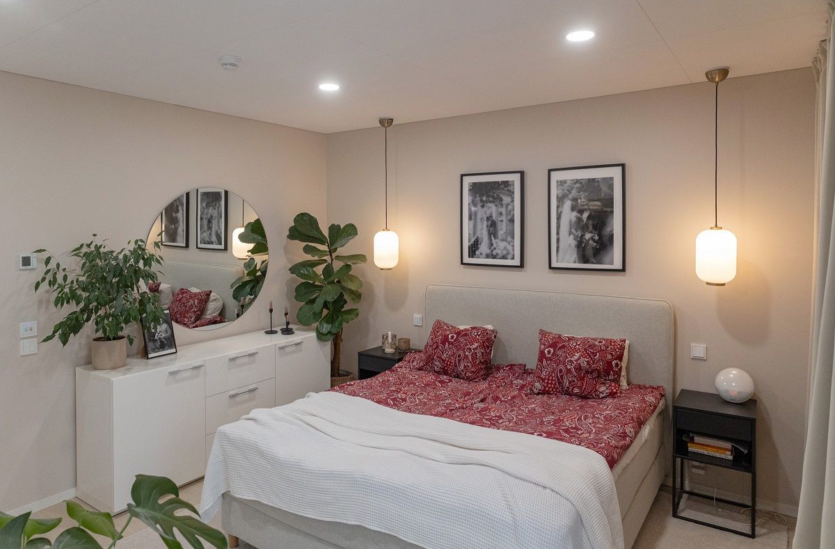 Piccoli pannelli led rotondi sul soffitto della camera da letto. Luci a sospensione aggiuntive su entrambi i lati del letto.