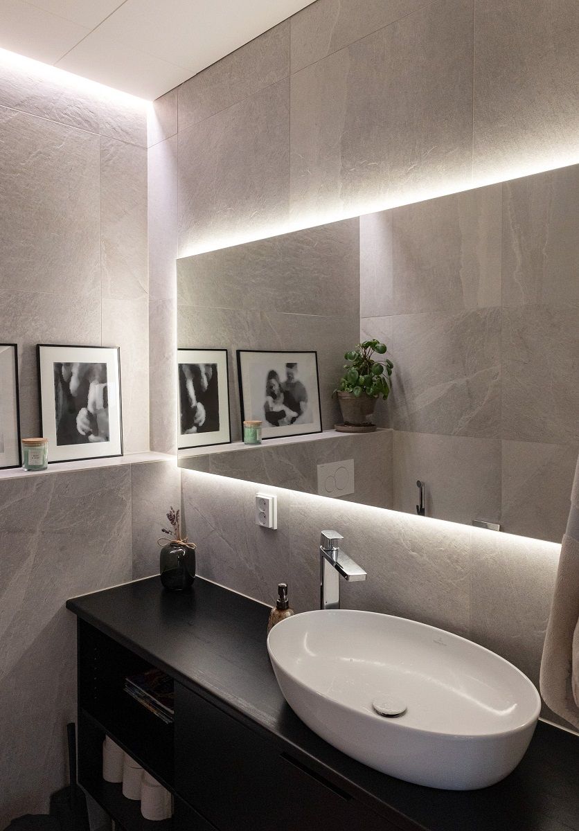 Striscia luminosa a LED incassata tra parete e soffitto e dietro lo specchio.