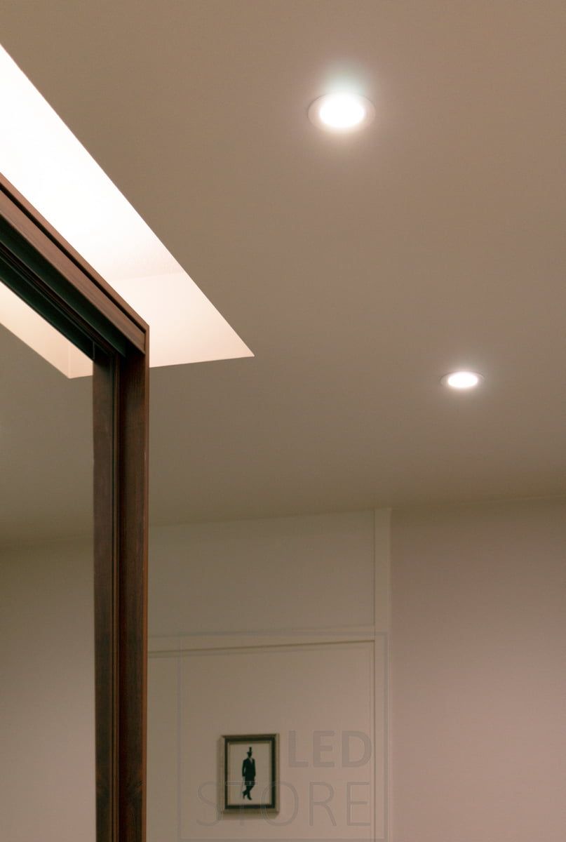 Sopra l'armadio ad ante scorrevoli del corridoio, una striscia LED con profilo superficiale bianco e 7,2 W/m con CCT atmosferico illumina il soffitto. LedStore.fi