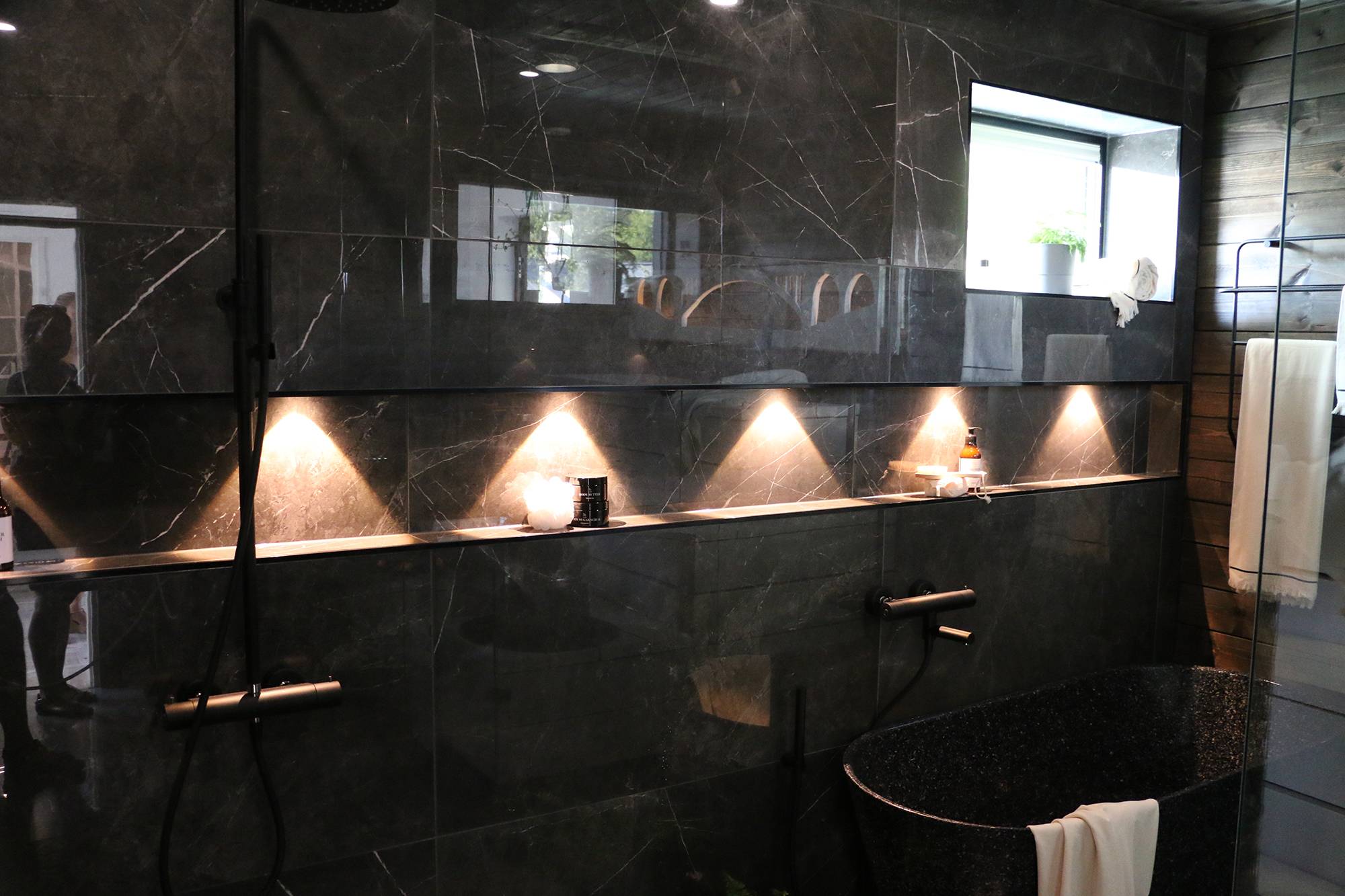 Nel bagno, i faretti mettono in risalto la mensola dello shampoo. Ledstore.fi