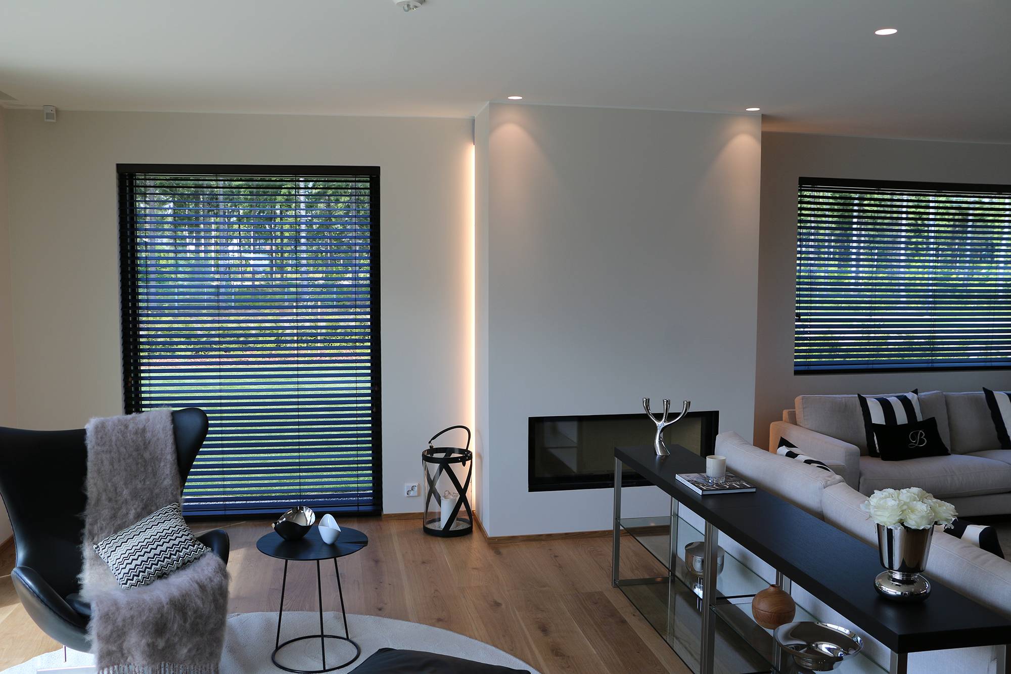 Camino messo in risalto da strisce led che attraversano la parete e da spot sul soffitto. Ledstore.fi