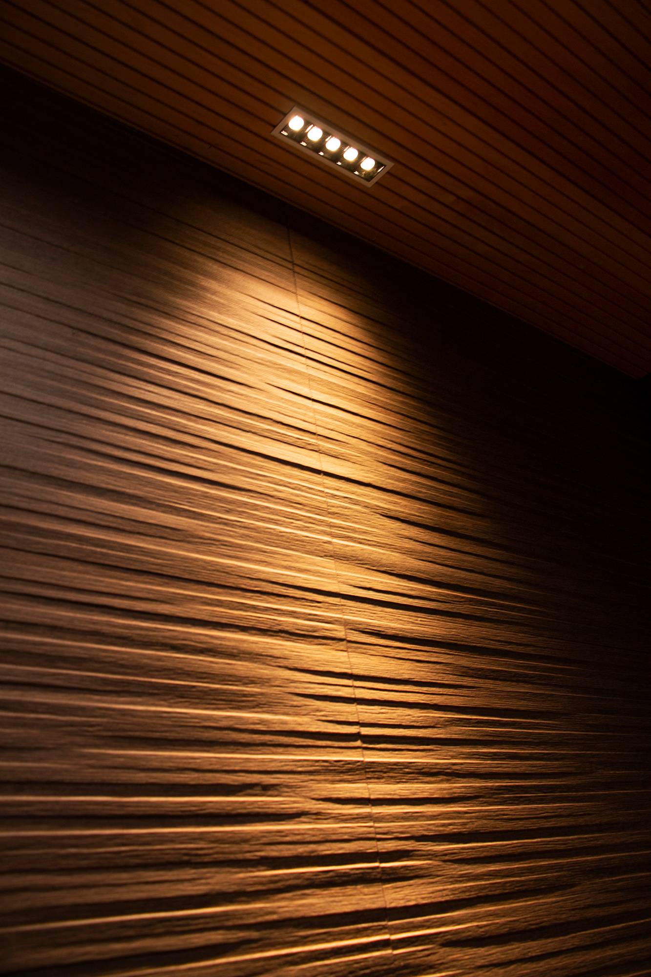 LINJA5 che evidenzia la texture del soffitto sulla parete. Ledstore.fi