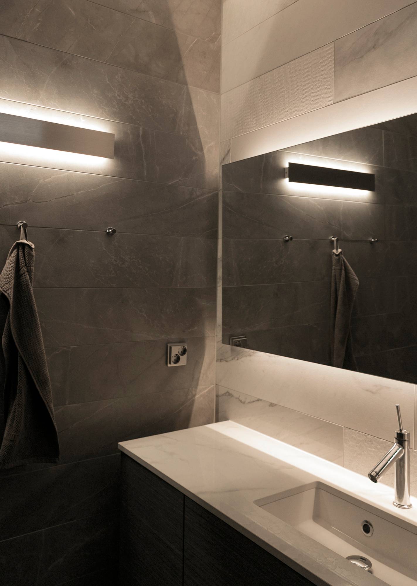 Evidenziare la superficie della texture con una lampada da parete che illumina indirettamente in due direzioni. Ledstore.fi