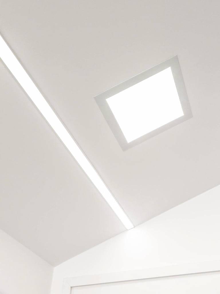 Sfondo verde con un quadrato bianco al centro con "LED STORE" in lettere bianche verticali - marchio di un negozio di illuminazione a LED.