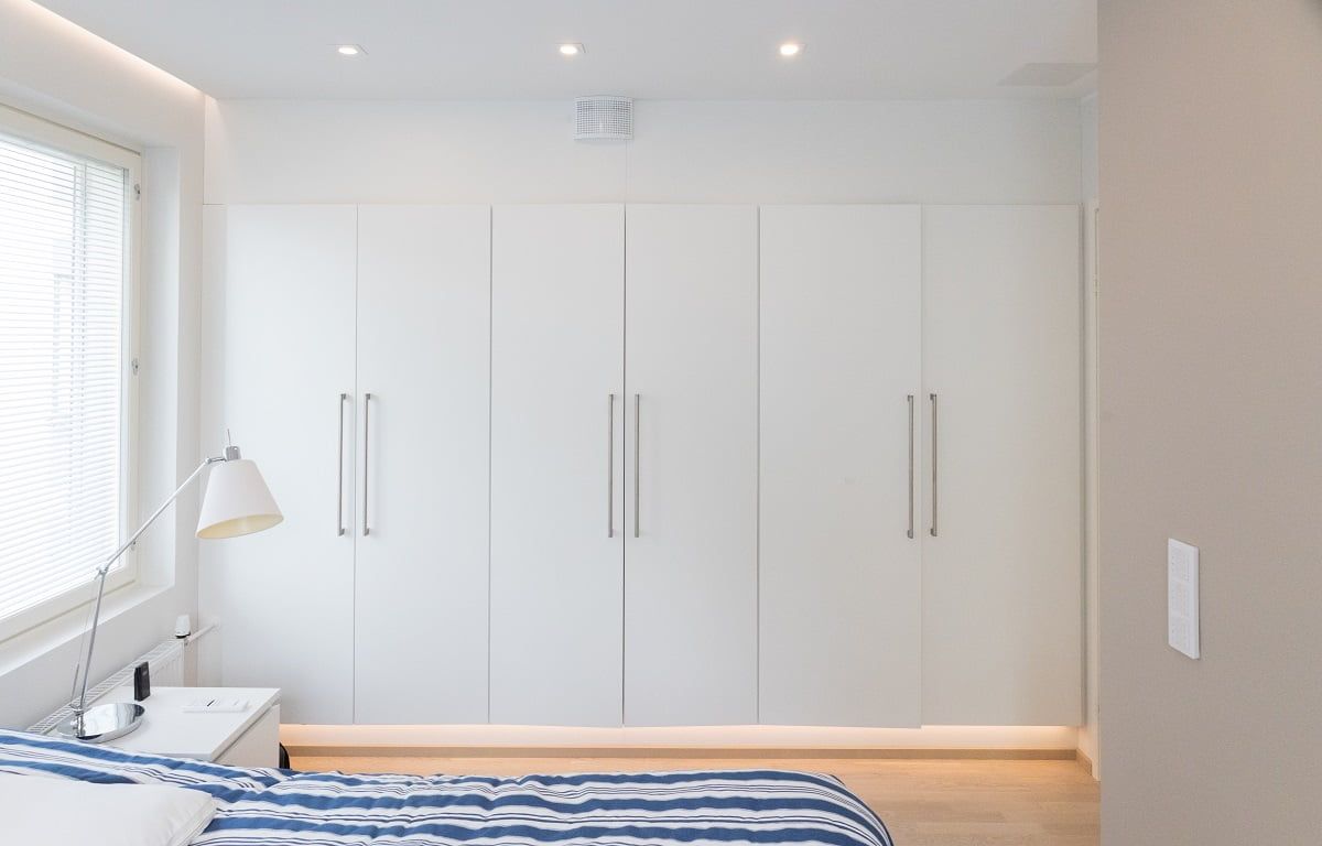 Davanti all'armadio, l'illuminazione generale è assicurata da faretti direzionali Kantti da 9W. Luce d'atmosfera per corridoio con profilo LED montato sulla base dell'armadio © LedStore