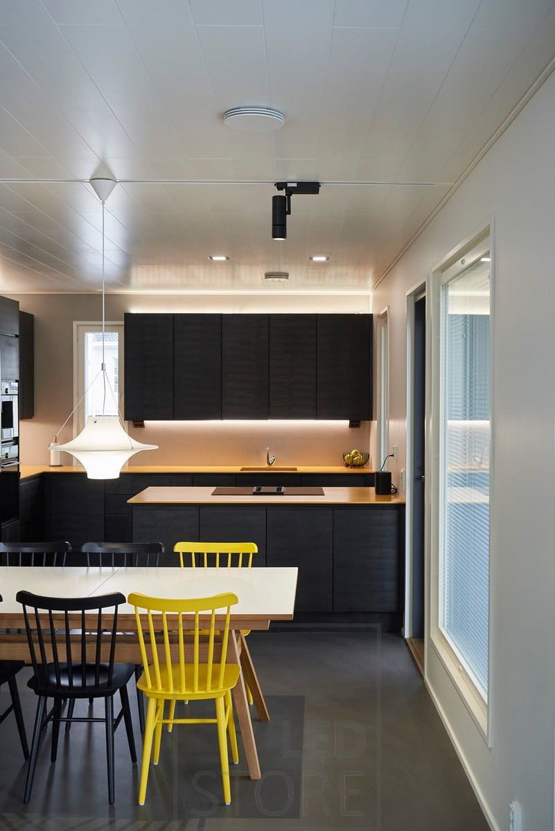 In cucina, strisce a led sulla parte superiore e inferiore degli armadietti superiori, che forniscono un'illuminazione d'atmosfera indiretta e un'illuminazione di servizio a livello della cucina. Nella zona pranzo, gli spot FOKUS di Ledstore su un binario trifase. Ledstore.fi