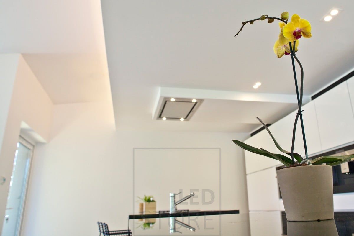 Luce indiretta e faretti a incasso in cucina. Una lunga goccia costruita sopra la cucina con una striscia LED nel labbro fornisce un'illuminazione indiretta e una bella stratificazione nello spazio. Ledstore.fi