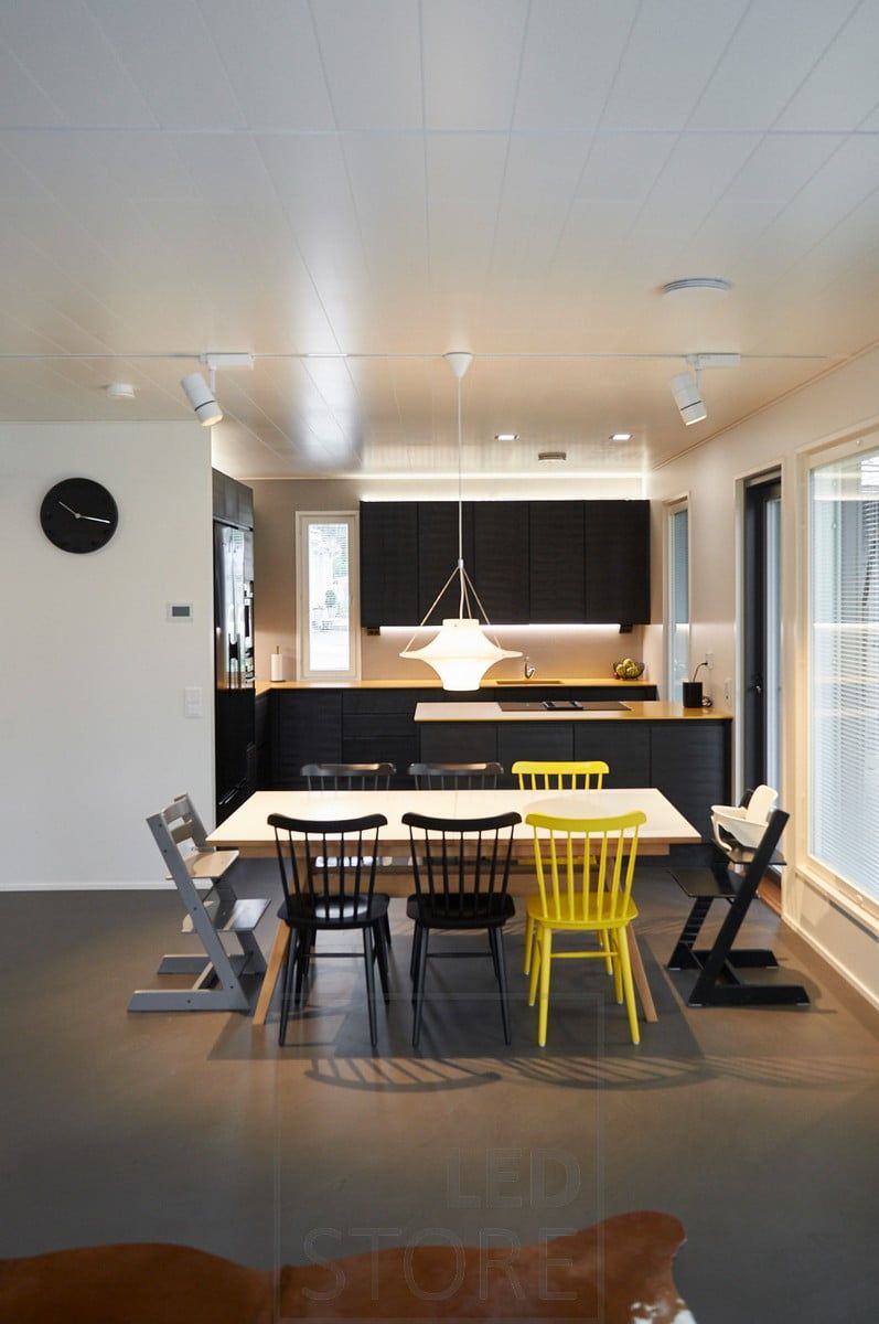 Illuminazione generale a binario trifase, illuminazione indiretta d'atmosfera con strisce LED sopra i mobili della cucina. Striscia LED sul fondo dei mobili superiori che illumina il piano di lavoro. Ledstore.fi