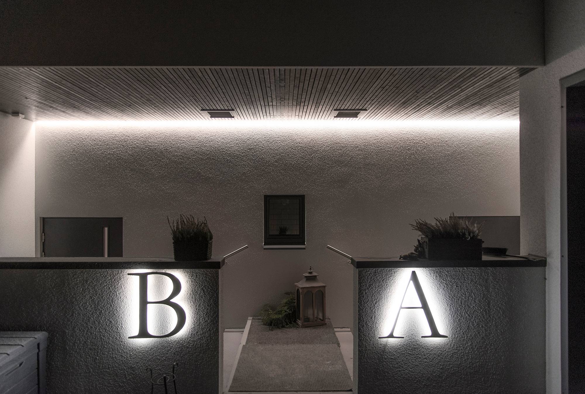 Le lettere esterne delle case illuminate da strisce LED e l\'ingresso illuminato da una striscia LED a luce indiretta. Ledstore.fi